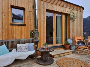 a wooden house with a couch and a table on a deck at UlMi's Tiny Haus in Dalaas