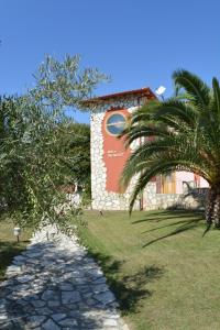 a building with a sign next to a palm tree at Petros Italos in Neos Marmaras +19 photos