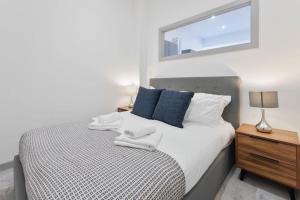 Schlafzimmer mit einem Bett und einem Wandspiegel in der Unterkunft Cosy 1 Bed Apartment Dudley in Dudley