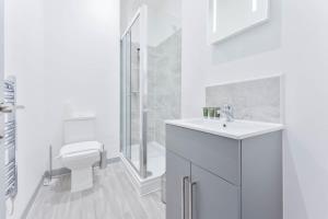 a white bathroom with a sink and a toilet at Cosy 1 Bed Apartment Dudley in Dudley