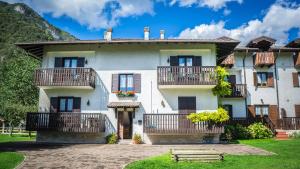 a large white house with balconies and a yard at Casa Enrico in Pieve Di Ledro