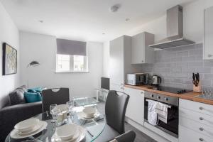 a kitchen with a table and chairs and a kitchen with a table and a kitchen at Cosy 1 Bed Apartment in Leeds in Leeds
