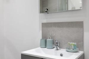 a bathroom sink with two cups on top of it at Cosy 1 Bed Apartment in Leeds in Leeds
