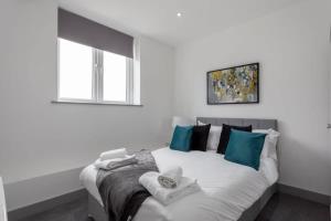 um quarto com uma cama com almofadas azuis e brancas em Charming 1 Bed Apartment in Leeds em Leeds