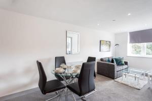 a living room with a glass table and black chairs at Charming 1 Bedroom Apartment in Leeds in Leeds
