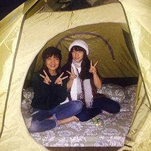 two girls sitting in a tent making the peace sign at Dalat Inn ez home in Da Lat