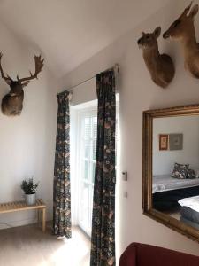 a room with a mirror and deer heads on the wall at Cozy, quiet guest house perfect for business or pleasure in Hillerød