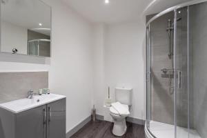 uma casa de banho com um chuveiro, um WC e um lavatório. em Modern 1 Bedroom Apartment Leeds em Leeds