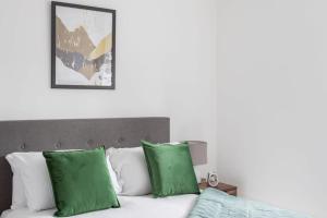 a bedroom with a bed with green and white pillows at Modern 1 Bedroom Apartment Leeds in Leeds