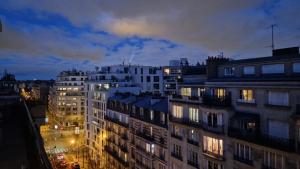 a view of a city at night with buildings at Michel Ange in Paris