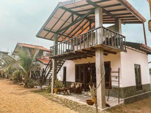 a house with a balcony on top of it at Stay Golden in Arugam Bay