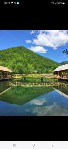 una gran masa de agua con una montaña en el fondo en Bungalov Perovic, en Andrijevica