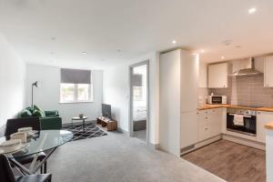 eine Küche und ein Wohnzimmer mit einem Tisch im Zimmer in der Unterkunft Cosy & Modern 1 Bed Apartment Leeds in Leeds
