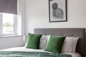 a bedroom with a bed with green and white pillows at Cosy & Modern 1 Bed Apartment Leeds in Leeds