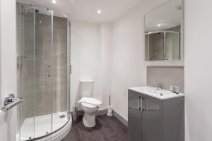 uma casa de banho com um chuveiro, um WC e um lavatório. em Cosy & Modern 1 Bed Apartment Leeds em Leeds