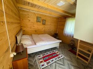 um quarto com uma cama num chalé de madeira em Bungalov Perovic em Andrijevica