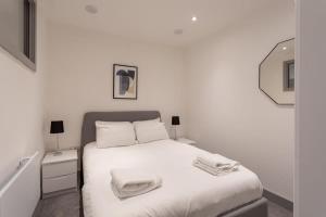 a white bedroom with a bed with towels on it at Fantastic 1 Bedroom Apartment Leeds in Leeds