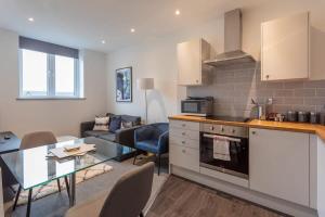 a kitchen and living room with a table and a couch at Fantastic 1 Bedroom Apartment Leeds in Leeds