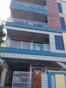 un edificio de apartamentos con porche y puerta en Madiraju homestay en Kurnool
