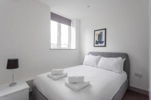 a white bedroom with a large white bed with two pillows at Contemporary 1 Bedroom Apartment Leeds in Leeds