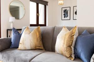 - un canapé avec des oreillers et un miroir dans l'établissement Spacious 1 Bed Mayfair Apartment with Balcony, à Londres