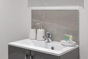 a bathroom sink with two rolls of toilet paper on it at Contemporary 1 Bedroom Apartment Leeds in Leeds