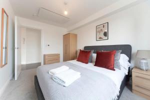 a bedroom with a large white bed with red pillows at Lovely 1 Bedroom Apartment in Ashford in Ashford