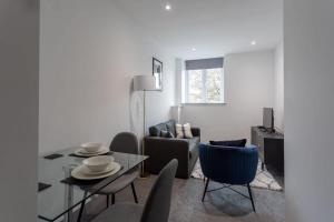 Amazing 1 Bedroom Apartment Leeds في ليدز: غرفة معيشة مع طاولة وكراسي
