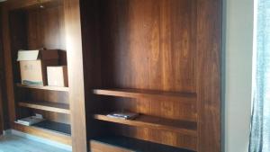 un armario con estanterías de madera y una caja en él en Madiraju homestay en Kurnool