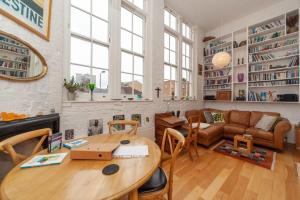 a living room with a table and a couch at Charming 1 Bedroom Apartment in old School House in London