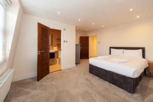 a bedroom with a large bed and a bathroom at Spacious 2 Bedroom Maisonette in Stratford in London