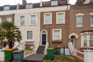 an old brick house with a blue door at Spacious 2 Bedroom Maisonette in Stratford in London