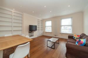 a living room with a table and a couch at Spacious 2 Bedroom Maisonette in Stratford in London