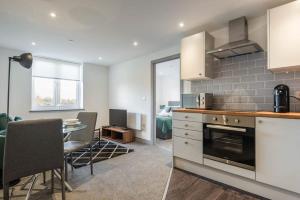 a kitchen with a table and a dining room at Cosy 1 Bed Flat in Leeds in Leeds