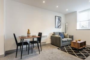 a living room with a table and a couch at Lovely Compact 1 Bed Apartment in Leeds in Leeds