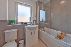 a bathroom with a toilet and a sink and a bath tub at Modern 1 Bedroom Apartment in Ashford in Ashford