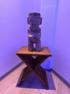 a statue sitting on top of a wooden table at Ononui Airport Studio in Faaa