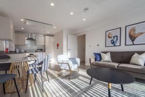 un soggiorno e una cucina con divano e tavoli. di Modern 2 Bedroom Apartment in Ashford ad Ashford