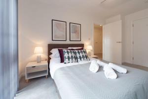 una camera da letto con un grande letto bianco con cuscini di Modern 2 Bedroom Apartment in Ashford ad Ashford