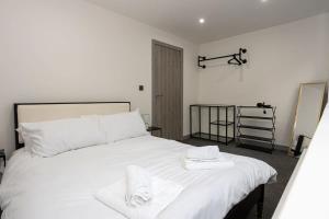a bedroom with a large white bed with towels on it at Modern 1 Bedroom Apartment in Preston Centre in Preston