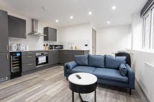 a living room with a blue couch and a table at Modern 1 Bedroom Apartment in Preston Centre in Preston
