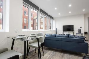 a living room with a blue couch and a table at Modern 1 Bedroom Apartment in Preston Centre in Preston