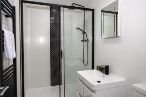 a white bathroom with a shower and a sink at Modern 1 Bedroom Apartment in Preston Centre in Preston