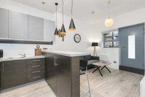 a kitchen with a counter and a dining room at Modern 1 Bedroom Apartment in Central Woking in Woking