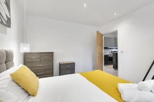 a bedroom with a white bed with a yellow pillow at Modern 1 Bedroom Apartment in Central Woking in Woking