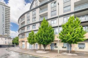 an apartment building with trees in front of it at Modern 1 Bedroom Apartment in Central Woking in Woking