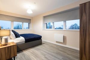 um quarto com uma cama e duas janelas em 2 Bedroom Modern Apartment in Manchester em Manchester