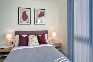 a bedroom with a bed with purple and white pillows at Contemporary 2 Bedroom Apartment in Ashford in Ashford