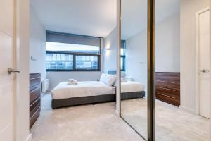 1 dormitorio con cama y espejo grande en Modern 2 Bedroom Apartment in Bracknell en Bracknell