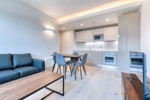 ein Wohnzimmer mit einem Sofa, einem Tisch und Stühlen in der Unterkunft Modern 2 Bedroom Apartment in Bracknell in Bracknell